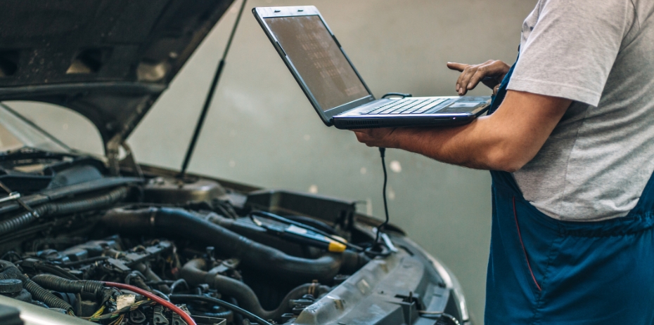 Osoba diagnozująca auto na komputerze